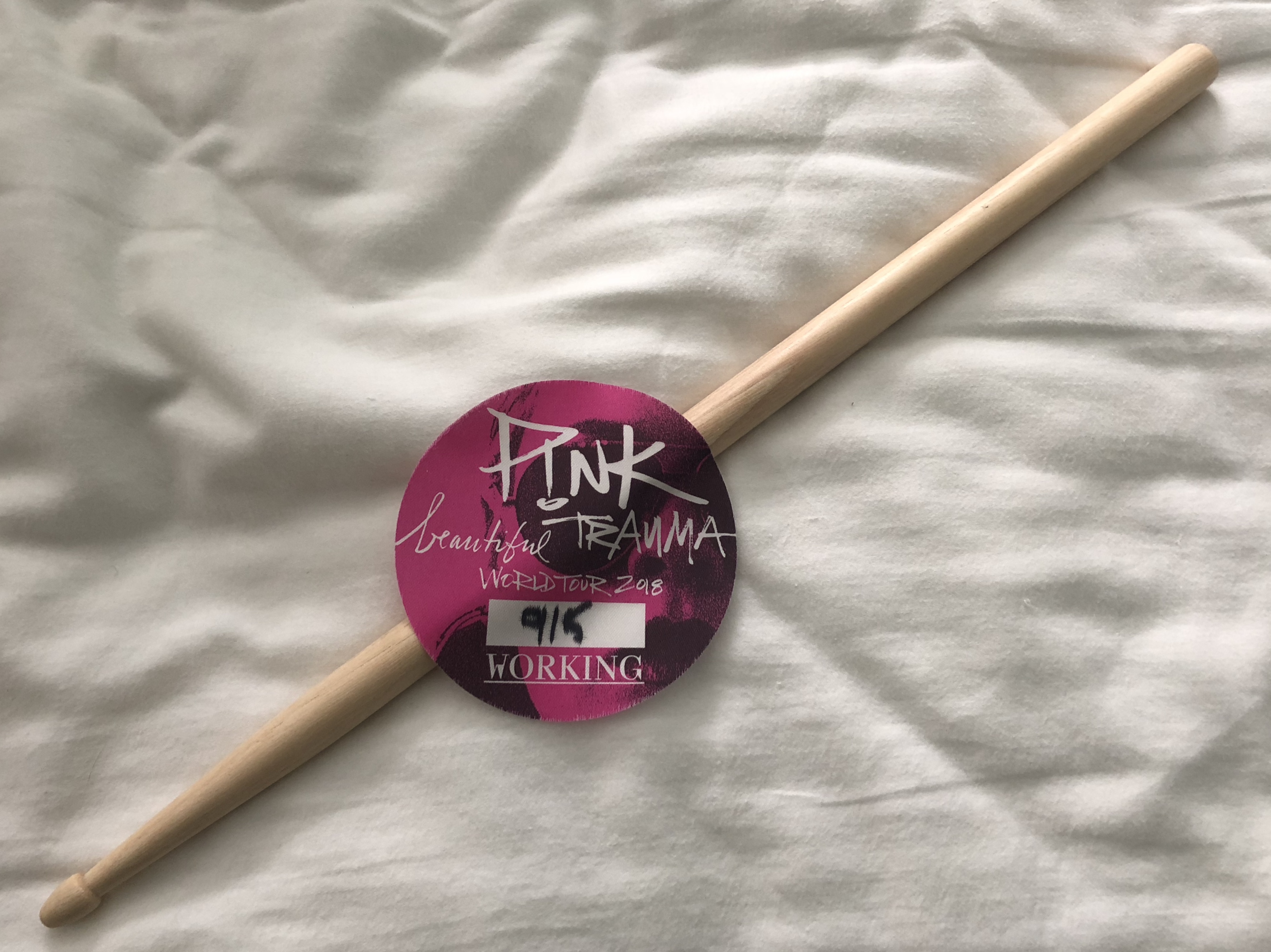 a drum stick and backstage pass