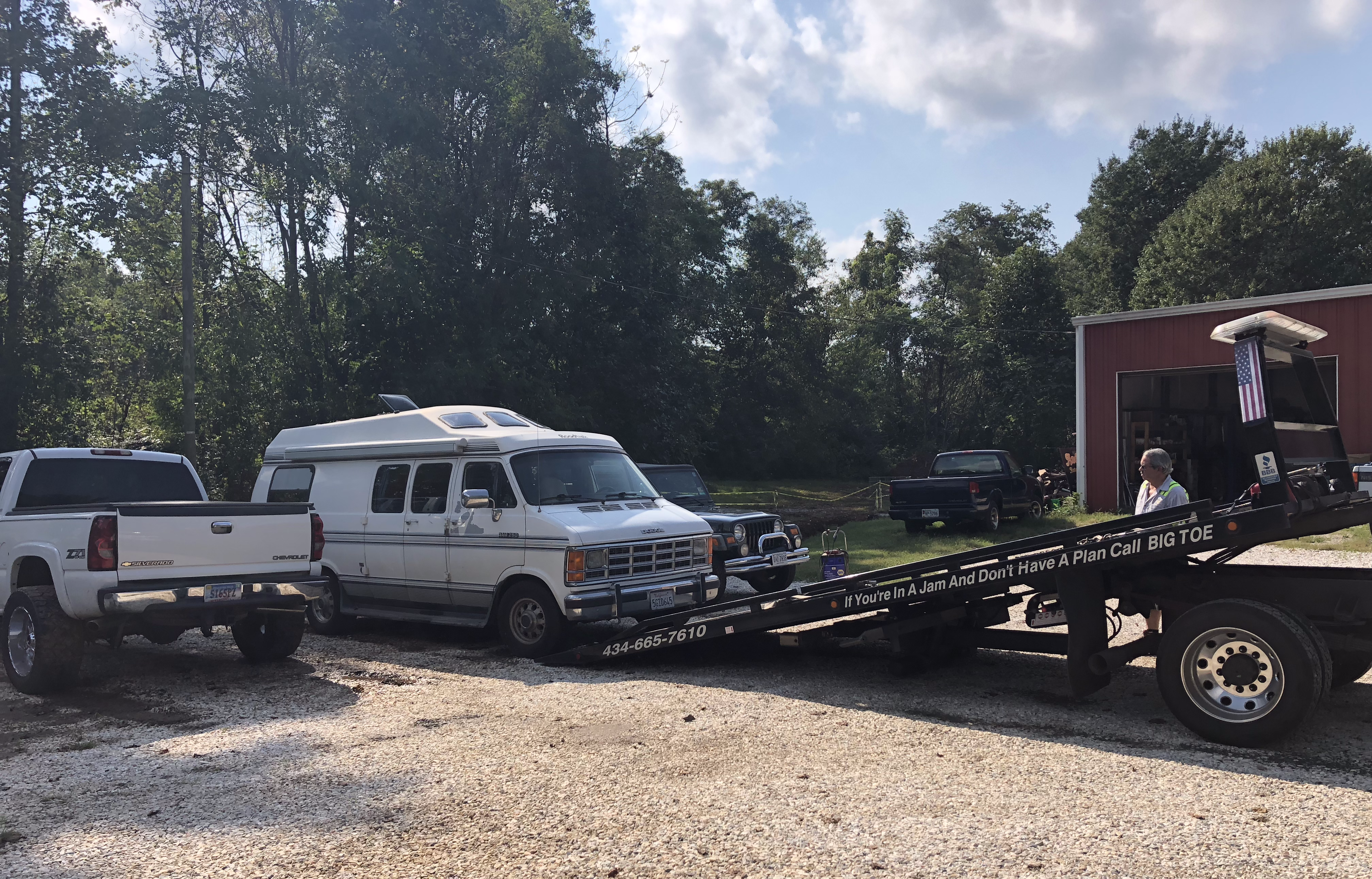 a Roadtrek being picked up by a flatbed tow truck