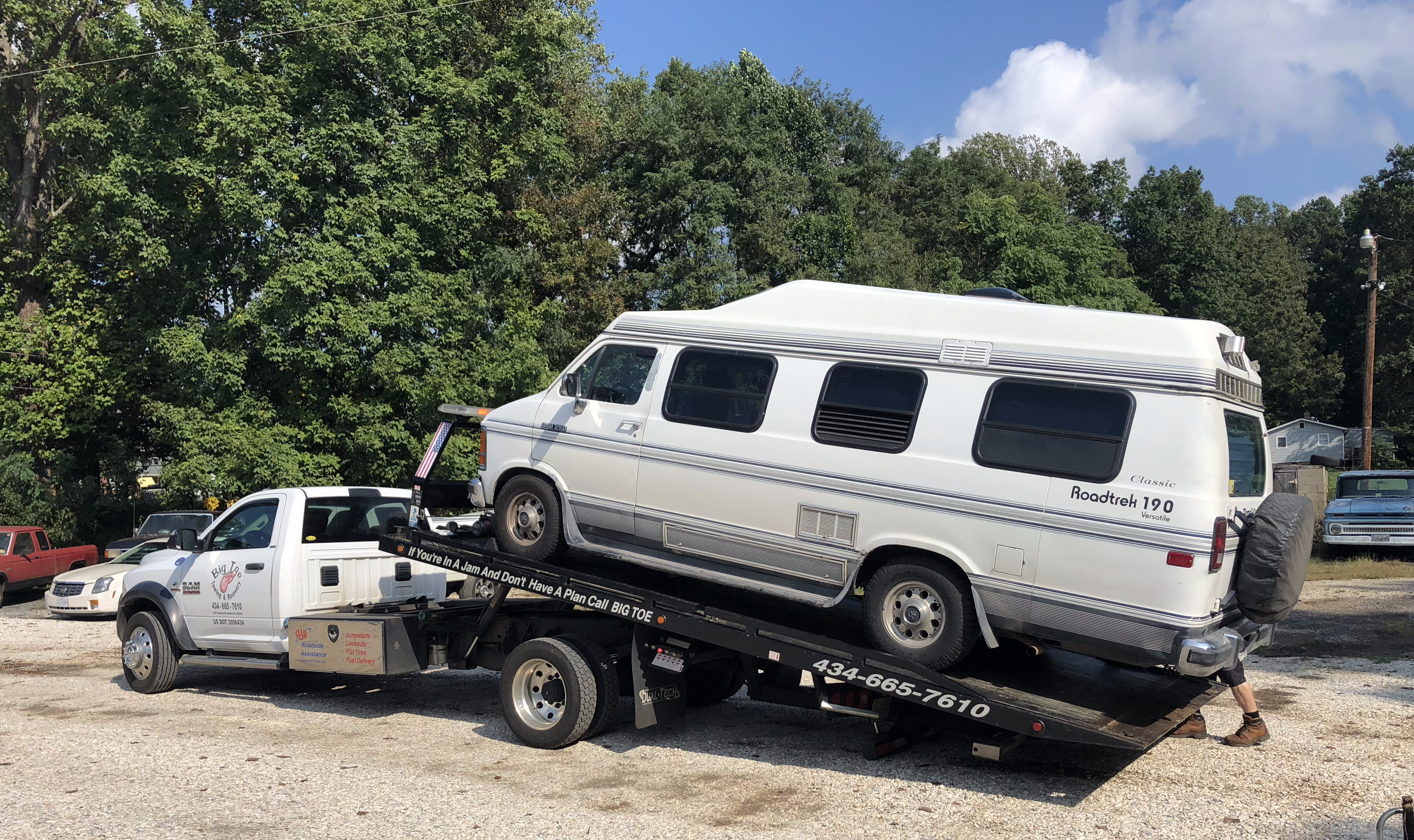 a Roadtrek on a flatbed tow truck