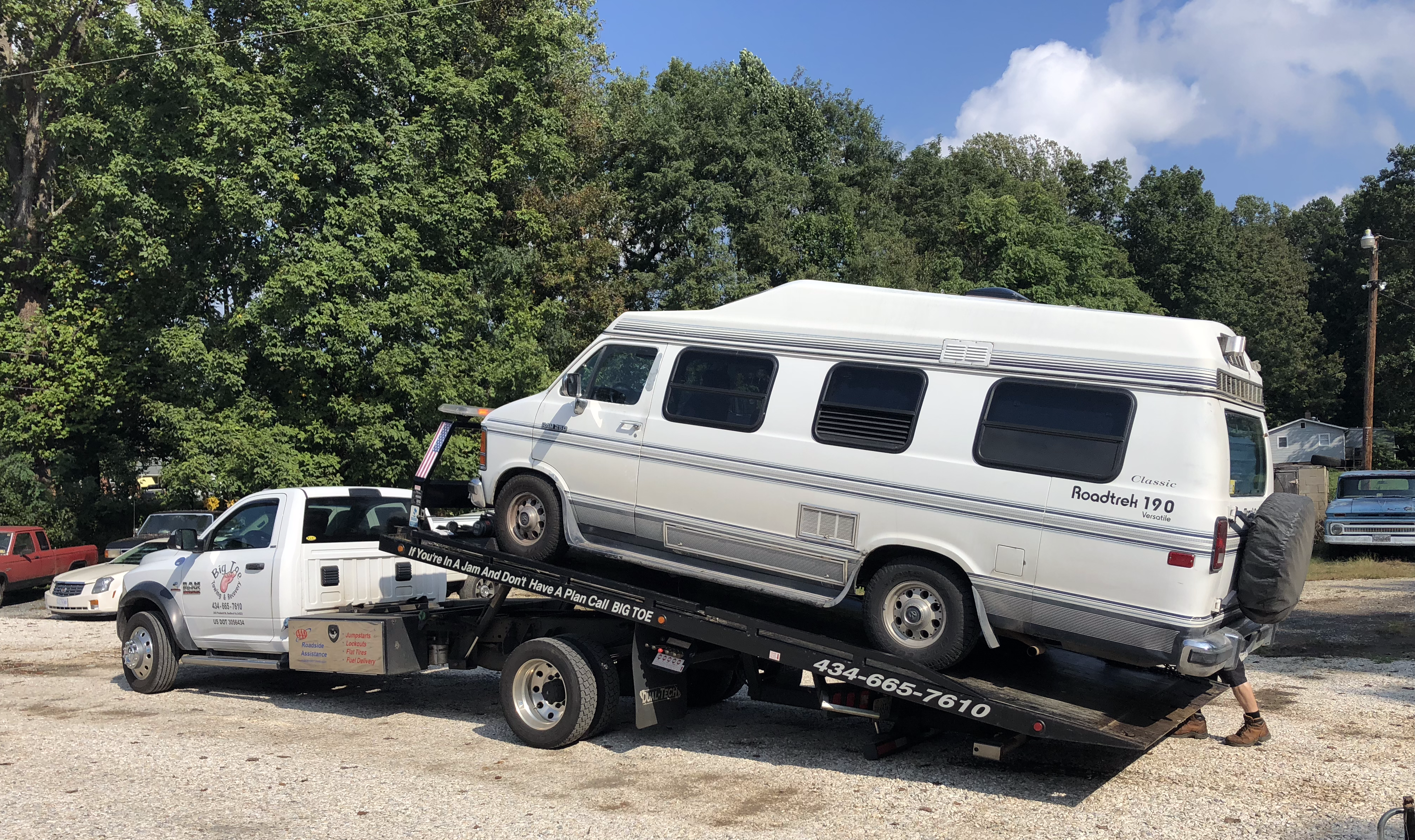 a Roadtrek on a flatbed tow truck