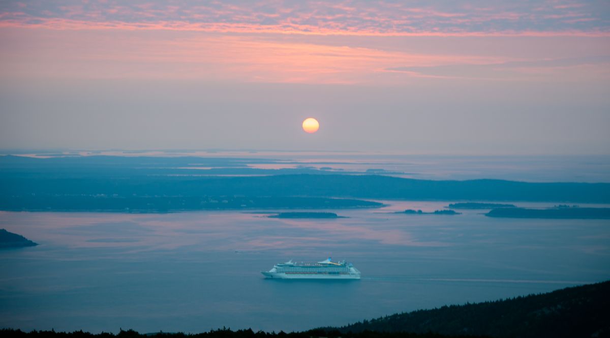 a cruise ship in front of a sunrise from Mount Desert Island, Maine